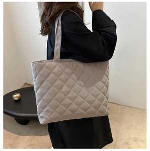 Detailed view of greige quilted tote bag showing high-quality nylon texture and wide handles