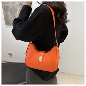 Chic orange half-moon shoulder bag with gold twist lock on minimalist leather exterior