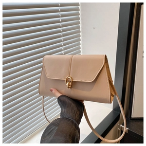 Close-up of beige PU leather shoulder bag featuring a gold interlocking metal chain lock