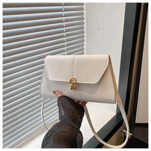 Detail of white rectangle leather bag with gold chain buckle and magnetic flap closure