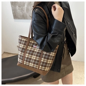 Brown plaid large shoulder tote bag with cute dachshund emblem worn by a model