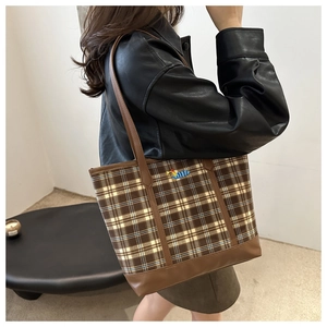 Side view of large plaid tote bag with colorful caterpillar embroidery and PU leather handles