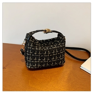 Classic black and white tweed underarm bag with gold metallic clasp and leather handle