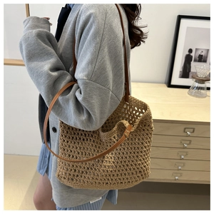 Detail of bohemian crochet tote with hollow mesh weave and brown leather shoulder strap