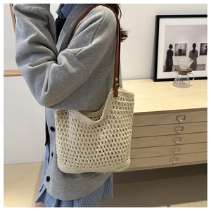 Detail of hand-woven crochet tote bag showing diamond mesh and brown leather straps