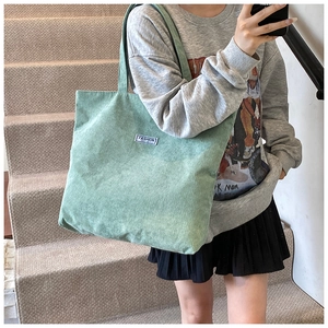 Dettaglio della borsa tote in velluto a coste verde menta con patch Fashion Instinct