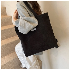 Dettaglio macro della borsa tote in velluto a coste nero con etichetta Fashion Instinct