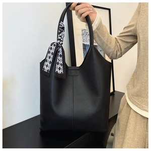 Close-up of black lychee grain tote bag with decorative checkered silk scarf on handle