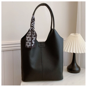 Close-up of black lychee leather tote with FASHION buckle and checkered silk scarf