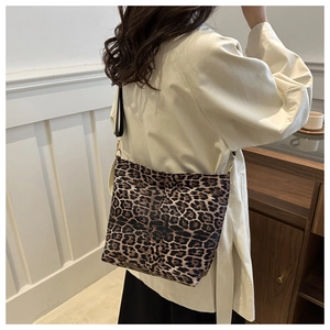 Close-up of leopard print shoulder bag with adjustable strap worn by a model