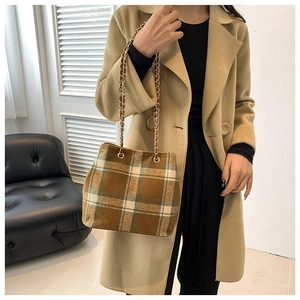 Vintage plaid shoulder bag with gold chain strap styled on model in camel coat