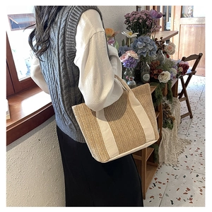 Detailed texture of woven straw tote bag with white canvas handle in a vintage setting