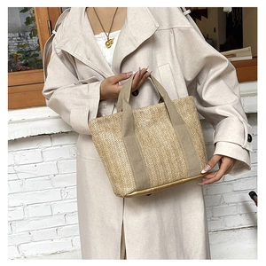 Detailed view of woven straw tote bag with V-shaped texture and comfortable webbed handles