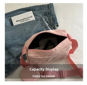 Pink nylon crossbody bag capacity display showing sunglasses and card holder inside
