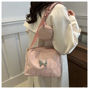 Detailed view of pink pleated handbag with silver butterfly charm and matching mini pouch