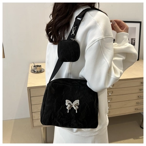 Detail of black pleated shoulder bag with silver butterfly charm and mini coin pouch