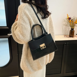 Elegante borsa nera da donna con goffratura a coccodrillo e dettagli in oro