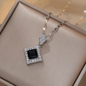 Elegant silver-tone necklace featuring a geometric black zircon pendant on a display box