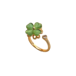 Adjustable gold ring with green clover and clear heart zircon on white background
