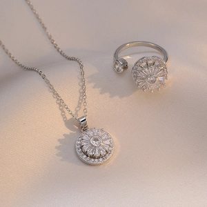 Elegantes Zirkonia-Schmuckset mit Sonnenblumen-Halskette und Ring auf Seidenhintergrund