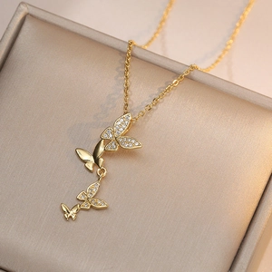 Collier papillon doré raffiné avec quatre pendentifs en zircon sur du satin champagne