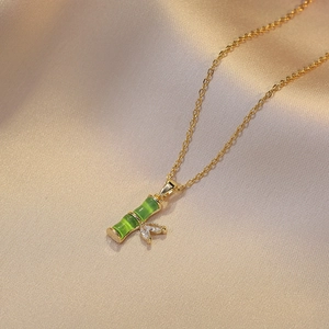 Collier élégant en titane doré avec pendentif bambou vert et zircons brillants