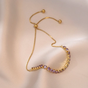 Elegant gold adjustable tennis bracelet featuring wavy purple zircon stones and slider clasp