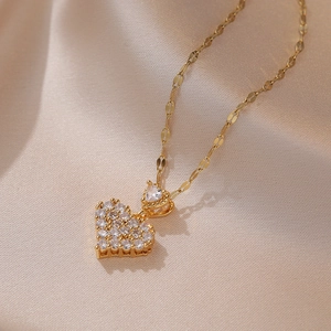Gros plan du pendentif double cœur doré serti de zircons sur fond de soie