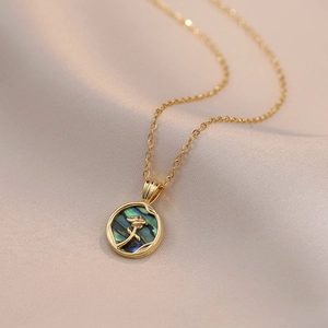 Collier rose dorée avec incrustation d'abalone sur fond en tissu satiné