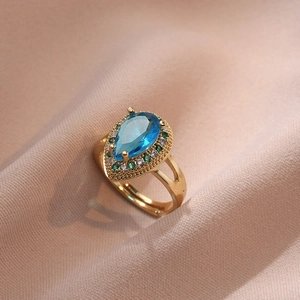 Bague en acier titane doré avec zircon saphir poire et halo de pierres précieuses