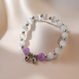 Bracciale di perle opale con accenti viola e ciondoli a campanella su seta beige