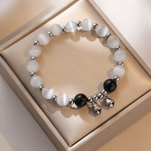 Elegant cat eye stone bead bracelet with obsidian accents and silver bell charms