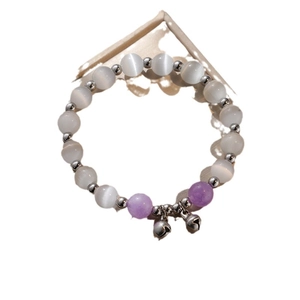 Cat eye stone bead bracelet with purple accents and silver bell pendants for women