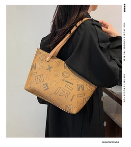 Detail of tan faux leather tote bag with embossed letters and MK MEMOXI branding