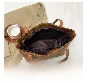 Detail view of the spacious brown tote bag interior with fabric lining and zip pocket