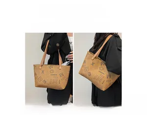Detail view of brown monogram tote bag showing handheld and shoulder carry options