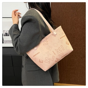 Chic pink tote bag with letter print shown on a model in a minimalist setting