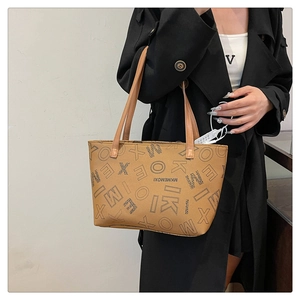 Vintage brown tote bag with letter prints and long handles shown in a lifestyle setting