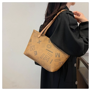 Brown faux leather tote bag with letter print and MK MEMOXI logo shown on female model