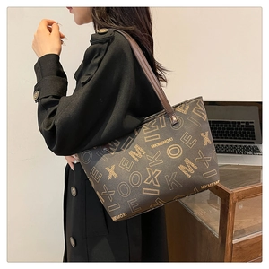 Detail of a large vintage brown monogram tote bag styled for office use