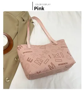 Detailed view of pink tote bag with brand letter printing and stylish hand straps