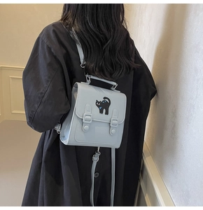 Detail of light blue PU leather backpack featuring a cute black cat patch on the cover