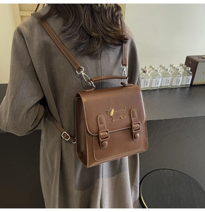 Detail of vintage brown leather backpack featuring a cute dachshund puppy embroidery