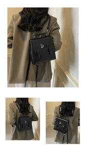Detail of black faux leather backpack featuring cute puppy metal clasp and top handle