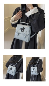 Detail of light blue mini backpack showing cat embroidery and multiple wearing styles
