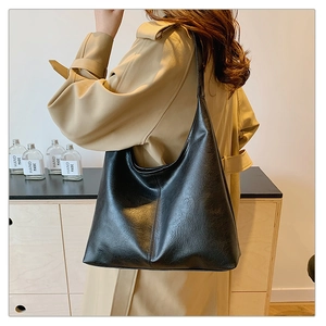 Vintage black hobo shoulder bag with wide strap and large capacity in a minimalist room