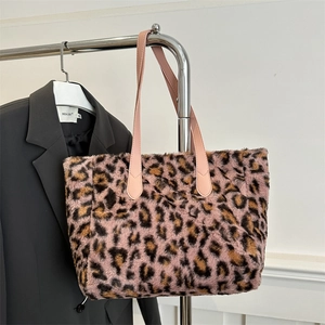 Pink leopard print faux rabbit fur tote bag with leather straps on a hanger