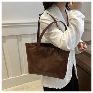 Λεπτομέρεια vintage καφέ τσάντας tote με γεωμετρικό ανάγλυφο μοτίβο και διπλούς ιμάντες ώμου