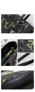 Close-up of golden butterfly embroidery and metal zipper on black jacquard tote bag