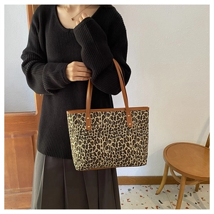 Leopard print tote bag with brown leather straps shown on model for daily use